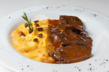 Delicious braised beef roast with creamy mashed potatoes. Loin with coffee and mashed potatoes. Wooden background. Close up.