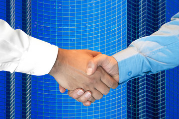 Businessmans partnership handshaking process. Skyscraper on the background