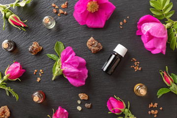 Bottles of essential oil with myrrh, frankincense and Rugosa roses