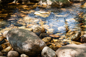 River stream passing between rocks, with huge rocks on the shore