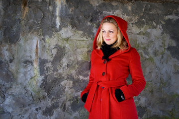 Young beautiful woman while standing in front of brick wall