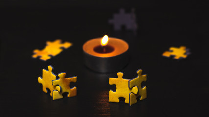 A group of puzzles standing in pairs around the candle. The concept of an integration meeting by the fire.