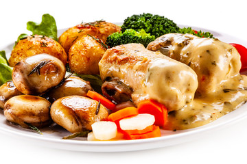 Wrapped pork chop with baked potatoes and vegetables