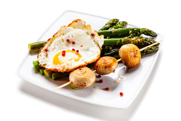 Fried egg with asparagus on white background