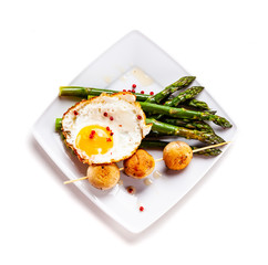 Fried egg with asparagus on white background
