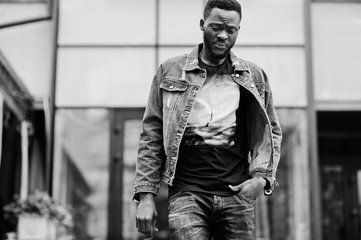 Fototapeta na wymiar Young attractive serious african american man model. Modern handsome guy in jeans jacket standing on urban city street.