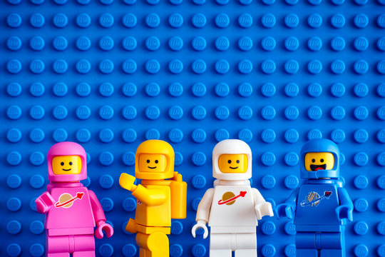 Tambov, Russian Federation - February 24, 2019 Four Lego astronaut minifigures against blue baseplate background. The LEGO Movie 2.