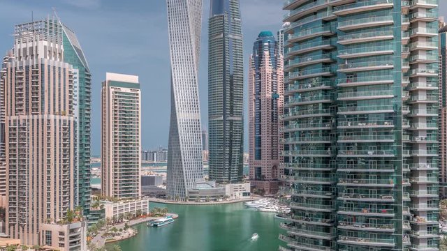 Aerial view of Dubai Marina residential and office skyscrapers with waterfront timelapse. Floating boats and yachts