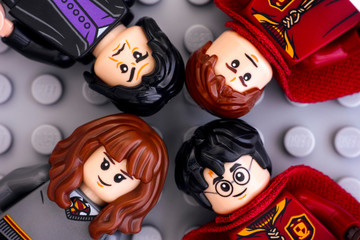 Fototapeta premium Tambov, Russian Federation - January 06, 2019 Four Lego Harry Potter minifigures - Harry Potter, Hermione Granger, Severus Snape and Oliver Wood on gray background. Studio shot.