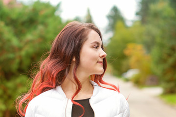 Fototapeta premium Portrait of a young beautiful girl with long hair in nature in autumn. Lifestyle.