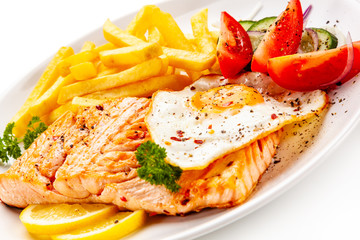 Fried salmon, French fries and vegetables