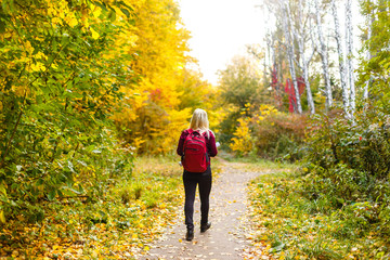 girl with a backpack in the autumn park