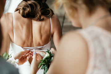 Moment of the lacing up the corset on the brides wedding dress