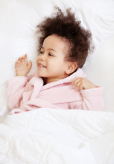 Cute little girl lying in cosy bed