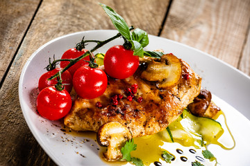 Grilled chicken fillet and vegetables on white plate