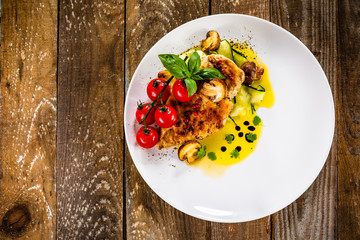 Grilled chicken fillet and vegetables on white plate