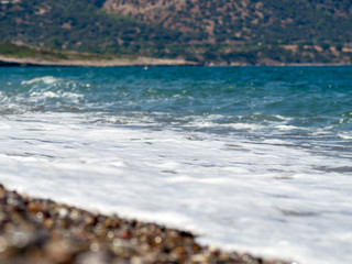 Pattern with turquoise sea stones beach on for design. Beautiful gravel background. Stone texture. Horizon sea water landscape. Image For desktop, wallpapers, banner. Copy space, selective focus