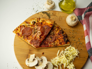 Mrożona pizza przygotowana w domu. Ser, oliwa, pieczarki, salami. Widok z góry, białe tło. - obrazy, fototapety, plakaty