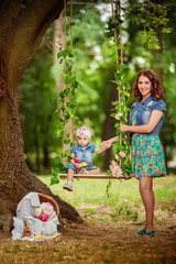 Beautiful  woman with young daughter in green garden