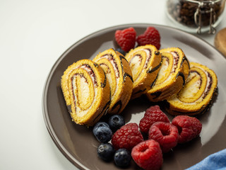 Słodka rolada z kremem i owocami. Pyszne ciasto na deser. Jasne tło.