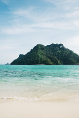 View from idyllic white sand beach shoreline of forested islands and turquoise waters in the Andaman Sea off Krabi Thailand