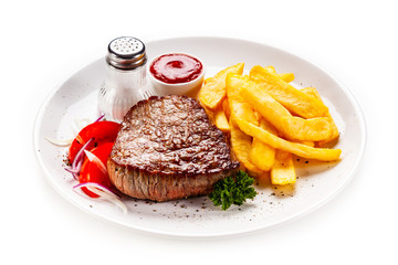 Grilled steaks, French fries and vegetables