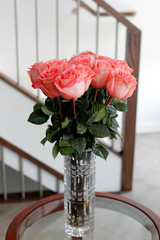 Deep Pink Roses Bouquet with Leaves in a Glass Vase on a Table