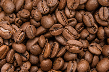 Brown roasted coffee beans background. Espresso dark, aroma, black caffeine drink. Close up / Top view