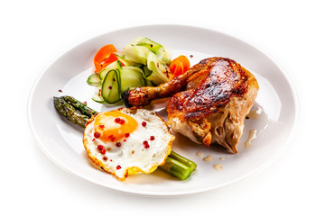 Fried egg with asparagus and chicken legon white background