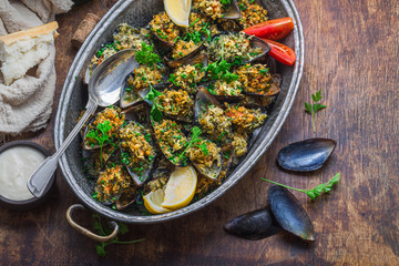 Mussels baked with cheese parmesan and bread crumbs, wine appetizer