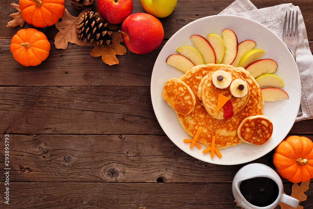 Poster cute thanksgiving turkey pancakes. top view corner border against a rustic wood background with copy