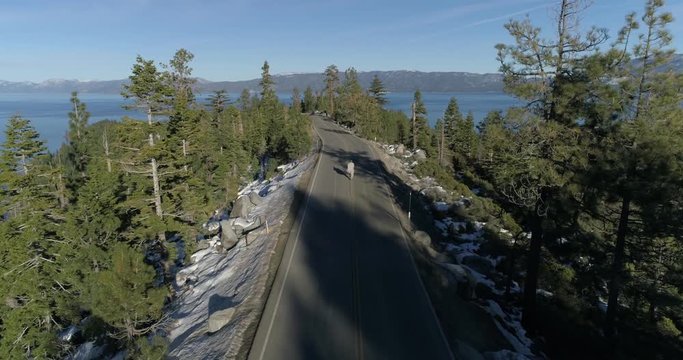 Aerial drone flight over running man at Lake Tahoe, USA, 4K, 60fps