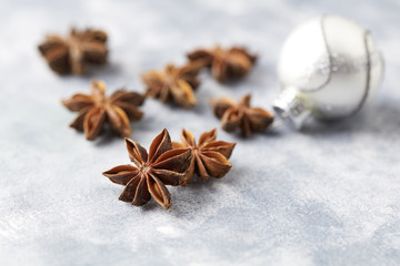 Obraz na płótnie Canvas Star anise and Christmas ball on bright wooden background. Close up. 