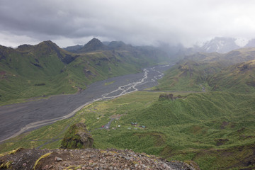 Iceland View form green Mountain Top over River with dramatic Clouds