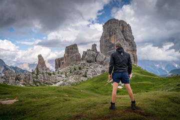 A man looking to the Cinque Torri at the Dolomites mountain in Italy.