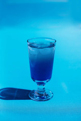 Coctail with ice on the blue background.