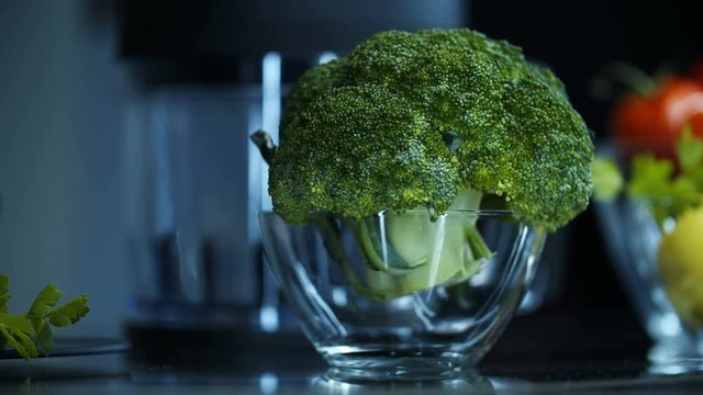 Fresh broccoli in a glass bowl in the kitchen among other ingredients. Healthy eating Vegetarianism.