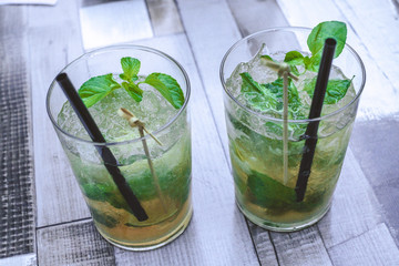 Summer drink, Mojito coctail with ice and mentha on the table.