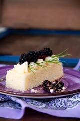 sliced cake with cream and blackberry