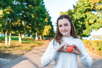Beautiful teenager girl 13-15 years old, summer autumn spring in park, red heart in her hand. Free...