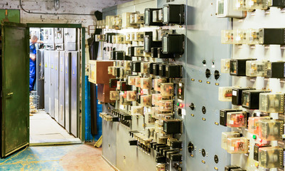 People work in a relay room at a power plant