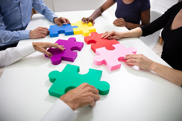 Businesspeople Building Colorful Jig Saw Puzzles Together