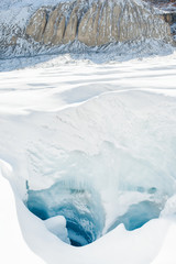 Ice crevasse hole in the rapidly melting Athabasca glacier of Columbia Icefield near the Icefields parkway in Jasper, Alberta, Canada / global warming and climate change concept