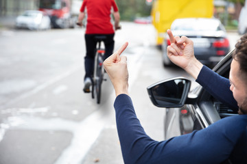 Angry Driver Showing Middle Finger To Woman Riding Bicycle