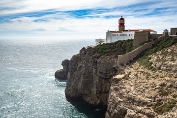 Fototapeta na wymiar The scenic lighthouse on the cliffs of Cabo de Sao Vicente(Cape St. Vincent) overlooking the Atalntic Ocean at the southwesternmost point of Portugal, Algarve
