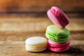 Multicoloured macarons on a dark wood background