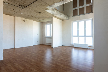 The interior of the spacious apartment without repair, with laminate flooring