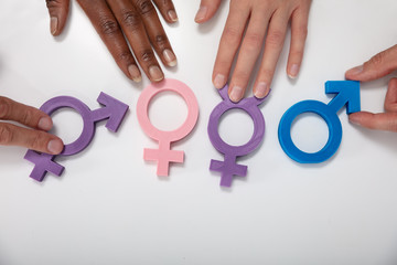 Multi Ethnic People Showing Gender Signs On Table