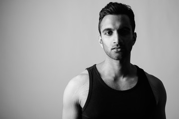 Young handsome Indian man against white background