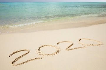 Fototapeta na wymiar 2020 Year Written On Sand Near The Sea At Beach